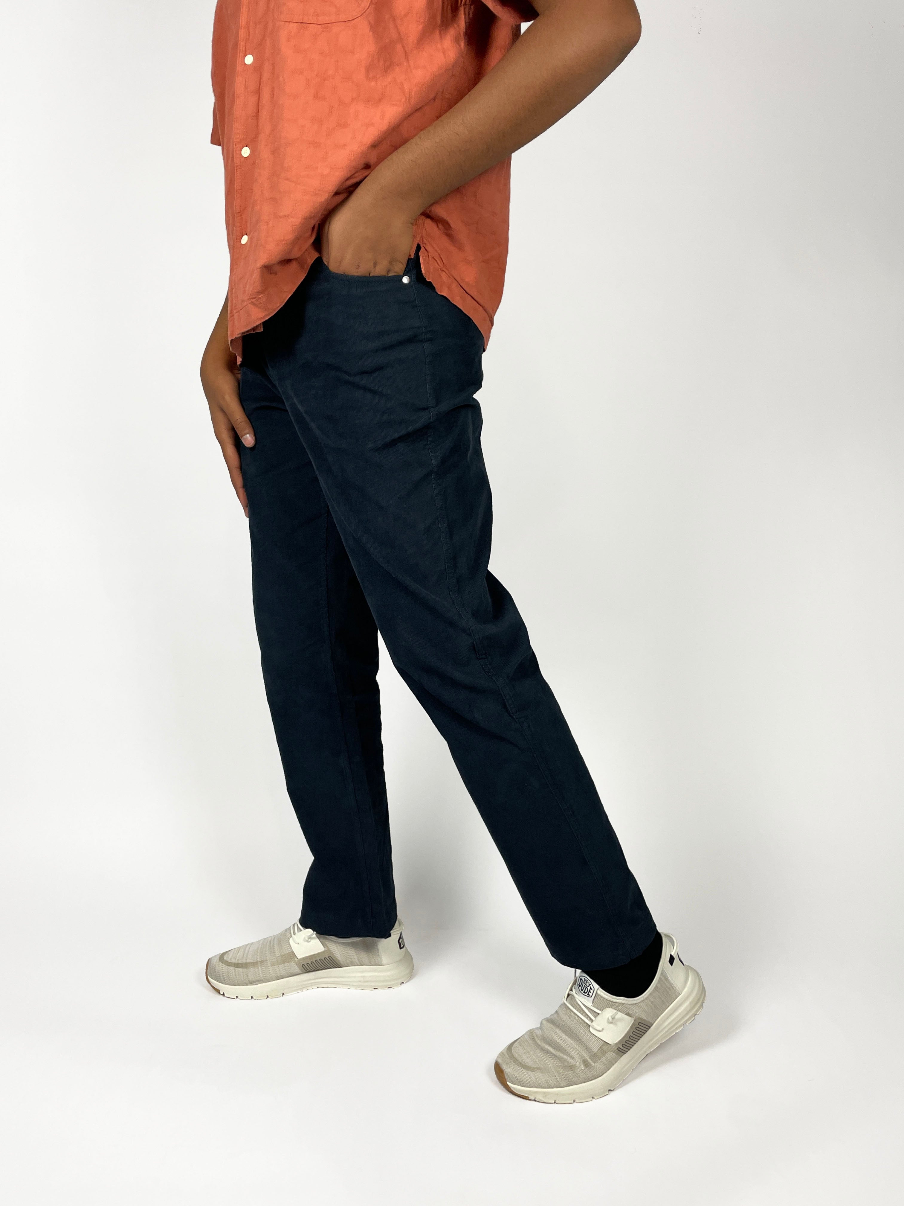 Man wearing Cordster style pants and an orange shirt on a white background