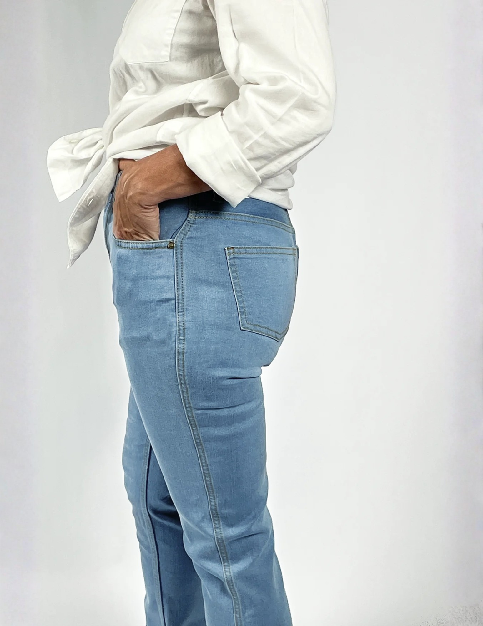 Woman wearing Say Yes to the Jeans style pants and a white shirt on a plain background